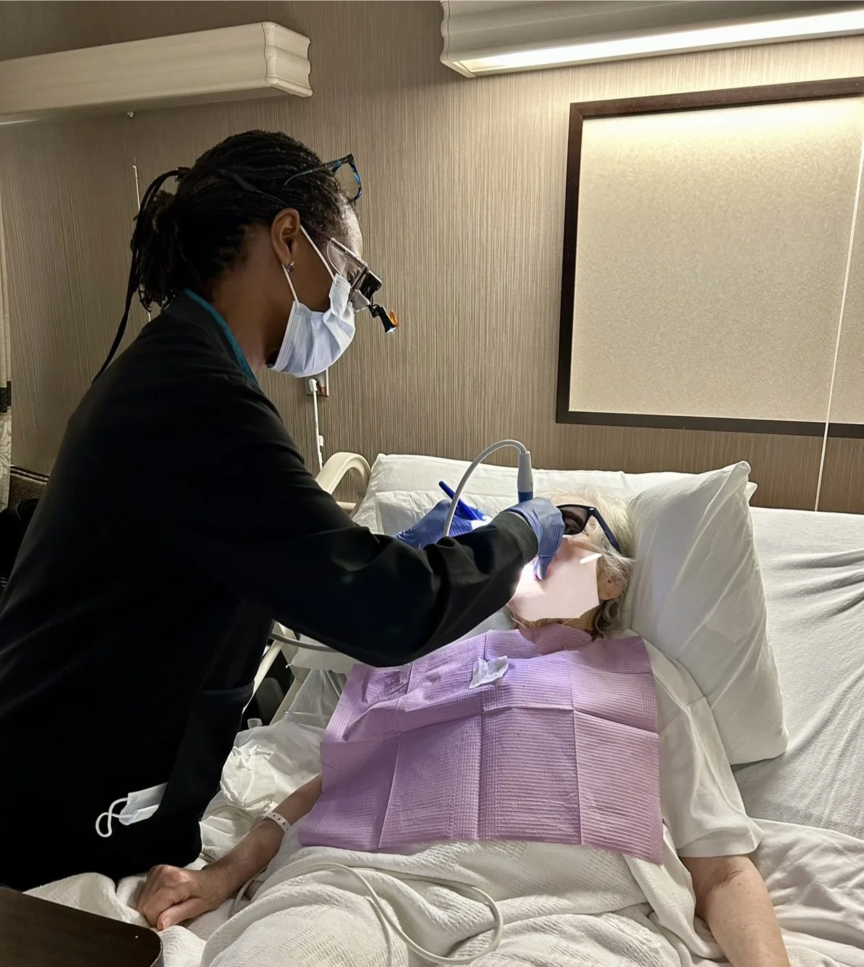 Cheryl providing dental hygiene care to a person resting in bed